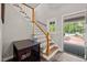 Bright foyer with wood stairs and a view of the front door with patterned rug and a glimpse of the outdoors at 9625 Collins Creek Dr, Chapel Hill, NC 27516