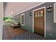 Inviting front porch features a wood door, outdoor seating, stylish lighting, and a beautiful patterned rug at 9625 Collins Creek Dr, Chapel Hill, NC 27516