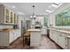 Bright, modern kitchen with white cabinets, stainless steel appliances, tile floors, and skylights at 9625 Collins Creek Dr, Chapel Hill, NC 27516