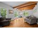 Bright living room with hardwood floors, exposed beams, and French doors to the outdoor space at 9625 Collins Creek Dr, Chapel Hill, NC 27516