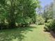 Spacious backyard featuring lush green lawn and mature trees, ideal for outdoor enjoyment at 101 Cardinal Dr, Youngsville, NC 27596