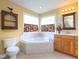 Bright bathroom featuring a corner tub, tiled walls, and a wood vanity with ample cabinet space at 101 Cardinal Dr, Youngsville, NC 27596
