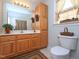 Bathroom featuring a vanity with sink, storage cabinet, toilet with basket, and a shower with curtain at 101 Cardinal Dr, Youngsville, NC 27596