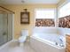 Bright bathroom features a corner tub, tiled walls, a shower, and a wood vanity with cabinet space at 101 Cardinal Dr, Youngsville, NC 27596