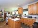 Bright kitchen with wood cabinets, an island, and views of the connected dining area at 101 Cardinal Dr, Youngsville, NC 27596