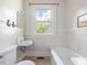 This is a quaint bathroom featuring a window, toilet, tub, and sink at 10186 W Nc-97 Hwy, Middlesex, NC 27557