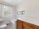 Bathroom featuring a window, toilet, tub, vanity with a white countertop and wooden cabinets at 10186 W Nc-97 Hwy, Middlesex, NC 27557