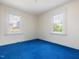 Bedroom boasts vibrant blue carpeting and natural light from two windows at 10186 W Nc-97 Hwy, Middlesex, NC 27557