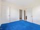 Spacious bedroom featuring two doorways, three doors, and blue carpet at 10186 W Nc-97 Hwy, Middlesex, NC 27557