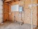 Close-up view of wall in garage interior, with shelves, pegboard, electrical box, and plumbing at 10186 W Nc-97 Hwy, Middlesex, NC 27557