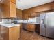 Close-up of kitchen featuring wood cabinets, subway tile backsplash, and stainless steel refrigerator at 10186 W Nc-97 Hwy, Middlesex, NC 27557