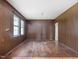 Open living room showcasing paneled walls, hardwood floors, and natural light from large windows at 10186 W Nc-97 Hwy, Middlesex, NC 27557