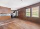 Spacious living room with wood-paneled walls, hardwood floors, and abundant natural light from multiple windows at 10186 W Nc-97 Hwy, Middlesex, NC 27557