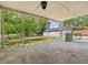 View from covered patio to backyard and detached two-car garage with mature trees surrounding the lawn at 10186 W Nc-97 Hwy, Middlesex, NC 27557