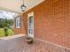 A red brick front porch with tile flooring creates a warm welcome, showcasing architectural charm at 10186 W Nc-97 Hwy, Middlesex, NC 27557