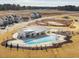Overhead image of the community pool and clubhouse set amongst residences and construction in a new development at 1024 Channel Drop, Zebulon, NC 27597
