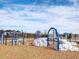 Community playground with climbing structures, swings, and a soft landing surface under a bright blue and cloudy sky at 1024 Channel Drop, Zebulon, NC 27597