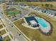 This aerial view captures the community pool, clubhouse, playground, and tennis courts in a picturesque setting at 1033 Channel Drop Lp, Zebulon, NC 27597