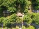 An aerial view of a home nestled amongst dense trees with a generous lawn at 108 Jefferson Dr, Durham, NC 27712