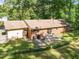 Brick home featuring a concrete patio area with seating and a spacious, lush green lawn at 108 Jefferson Dr, Durham, NC 27712