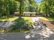 Well-maintained single-story home with mature trees, a long driveway, and a lush green lawn at 108 Jefferson Dr, Durham, NC 27712