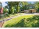 Inviting single-story home with a lush green lawn, mature trees and a long paved driveway at 108 Jefferson Dr, Durham, NC 27712