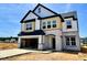 Two-story home showcasing light stone accents, a two-car garage, and stylish black and white trim at 109 Moonflower Ln # Homesite 260, Wilson's Mills, NC 27520
