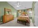 Charming bedroom with green walls, a floral-patterned bed, and a natural wood dresser at 1096 Kelso Ln # 18, Burlington, NC 27215