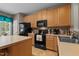 Well-equipped kitchen with black appliances, wooden cabinets, and tiled backsplash provides functionality at 1096 Kelso Ln # 18, Burlington, NC 27215