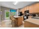 Bright eat-in kitchen boasts wooden cabinets, black appliances, and a view to the backyard at 1096 Kelso Ln # 18, Burlington, NC 27215