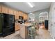 Open kitchen features wooden cabinets, black appliances, and a central island with bar stool seating at 1096 Kelso Ln # 18, Burlington, NC 27215