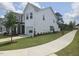 Exterior view of a two-story townhome with a well-maintained lawn and neighborhood sidewalk at 12 Lavender Ln, Clayton, NC 27520