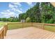 Wide shot of a wood back deck and backyard with trees and a shed at 123 Sanders Road Rd, Benson, NC 27504