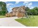 Exterior of a two-story home with a wood back deck and swing set at 123 Sanders Road Rd, Benson, NC 27504