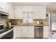 This kitchen has white cabinetry, a stainless steel dishwasher, and light granite countertops at 123 Sanders Road Rd, Benson, NC 27504