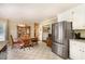 Kitchen with checkered tile floor, dining table, stainless refrigerator, and wood cabinets at 123 Sanders Road Rd, Benson, NC 27504