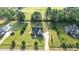 Aerial view of a modern farmhouse with a well-maintained lawn, playground and mature trees at 15 Willow Bend Dr, Youngsville, NC 27596