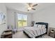 Bright bedroom featuring a large window, ceiling fan, carpet, and comfortable furnishings at 15 Willow Bend Dr, Youngsville, NC 27596