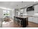 Bright kitchen features a central island with seating, pendant lights, and modern white cabinets at 15 Willow Bend Dr, Youngsville, NC 27596