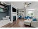 Cozy living room has a fireplace, mounted TV, a ceiling fan and hardwood floors at 15 Willow Bend Dr, Youngsville, NC 27596