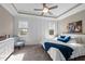 Serene bedroom featuring a tray ceiling, plush carpet, and bright natural light from two windows at 15 Willow Bend Dr, Youngsville, NC 27596
