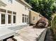A stone patio with a wooden deck, steps, wood siding, and backyard landscaping at 1605 Park Dr, Raleigh, NC 27605