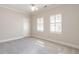Bedroom features neutral carpet, ceiling fan, and base trim with natural light from two windows at 1605 Park Dr, Raleigh, NC 27605