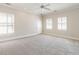This carpeted bedroom features two windows and a ceiling fan for added comfort at 1605 Park Dr, Raleigh, NC 27605