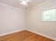 This bedroom has hardwood floors, a ceiling fan, and a window overlooking the backyard at 1605 Park Dr, Raleigh, NC 27605