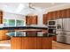 Well lit kitchen features wood cabinets, stainless steel refrigerator, and dual islands at 1605 Park Dr, Raleigh, NC 27605