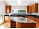 Kitchen features wooden cabinets, granite counters, island with a wine rack, and a garden view at 1605 Park Dr, Raleigh, NC 27605