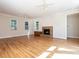 Spacious living room with a brick fireplace, hardwood floors, large windows, ceiling fans and recessed lighting at 1605 Park Dr, Raleigh, NC 27605