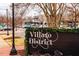 Charming Village District sign welcomes visitors with beautiful landscaping and shopping in the background at 1605 Park Dr, Raleigh, NC 27605