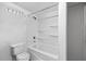 Picture shows a bathroom with a modern toilet, and a shower-tub combination with shelves at 1924 Strebor St, Durham, NC 27705